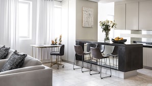 Une cuisine moderne dotée d’un îlot central, de tabourets de bar et d’un coin repas avec une table et des chaises.