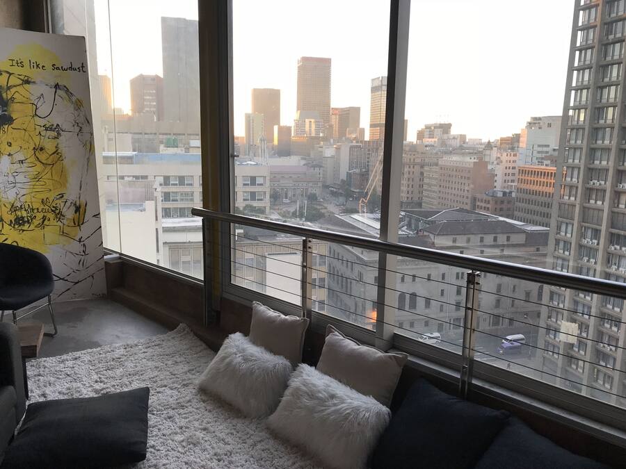 Quarto moderno com uma grande janela com vista para a paisagem urbana.
