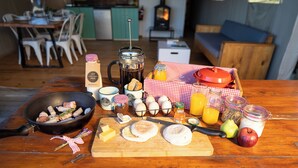 Un plateau de petit-déjeuner avec des œufs, du bacon, du fromage et des fruits, disposés sur une table en bois.