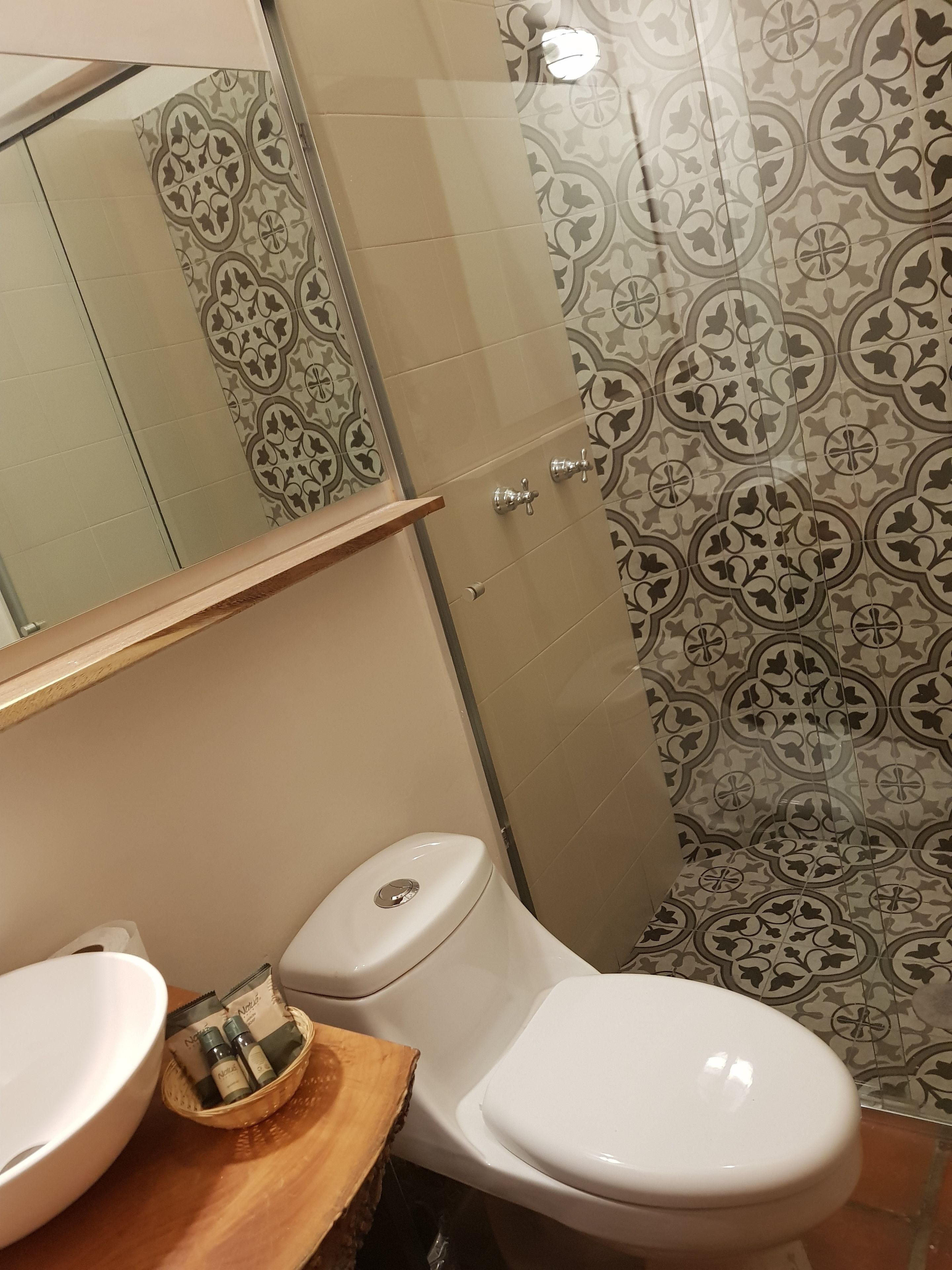 A bathroom with a toilet, a sink, and a shower area.