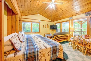 L’intérieur d’une cabine comprenant un lit, un canapé, une table à manger et un téléviseur.