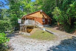 Eine Holzhütte mit einer Veranda und einer Treppe zu einer Terrasse.