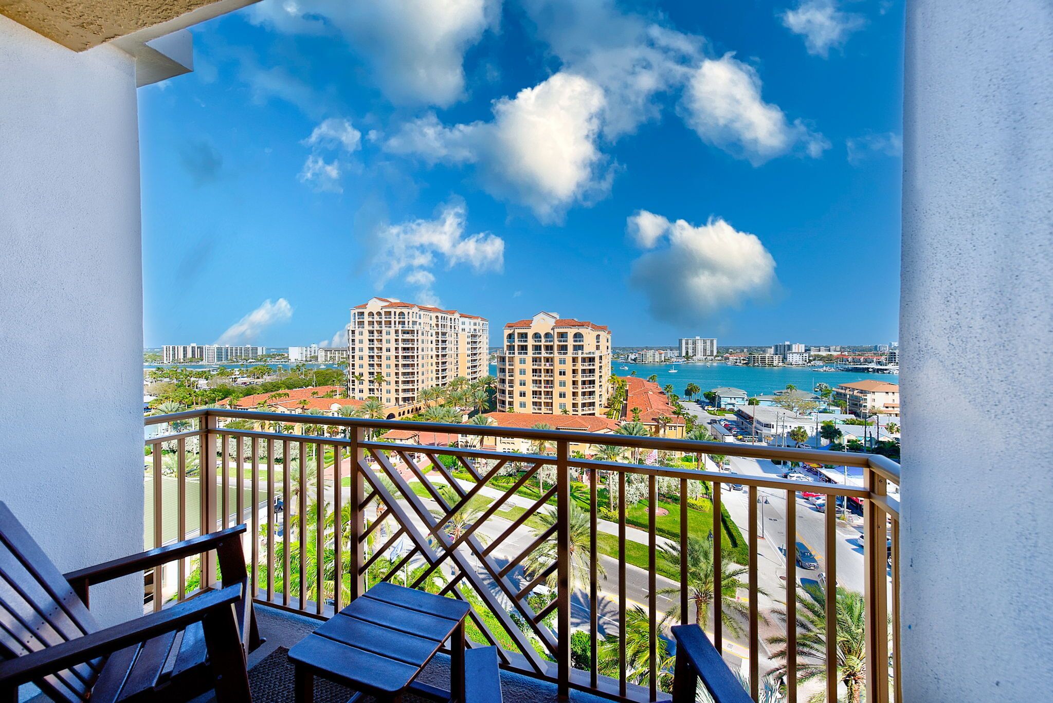 A balcony with a view of high-rise buildings and a body of water.