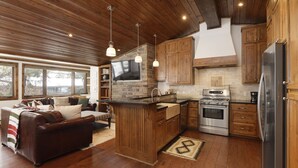 A spacious kitchen with wooden cabinets, a built-in stove, and a large island with a sink. - Modern Ski-in/Ski-out Condo with Pool and Hot Tub Access (Aspen)