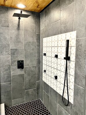 Tina con regadera, tina de hidromasaje, toallas, papel de baño