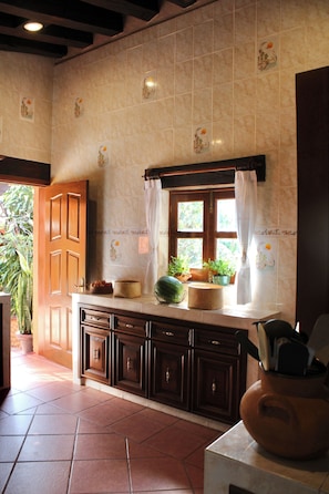 Una cocina con ventana, armarios y plantas en macetas.