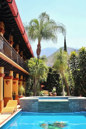 A pool with a stone edge, a wooden lounge chair, and a palm tree. - Terra-Cotta Villa - Private Retreat - Best Neighborhood (Agencia Municipal de San Felipe del Agua)