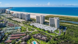 Een kustresort met hoge gebouwen, een strand en een golfbaan.