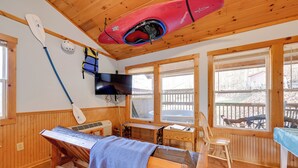 Una cabaña de madera con sauna, televisión y una tabla de remo.