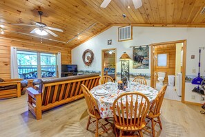 A wooden interior with a dining area, a bench, and a television. - 'Bear Den' Cabin: Hot Tub, 4 Mi to Nantahala River (Bryson City)