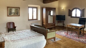 Une pièce comprenant un lit, une armoire en bois, un téléviseur et une chaise.