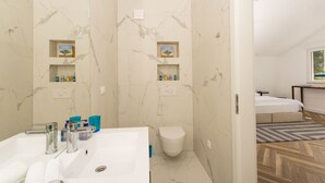 Une salle de bain moderne avec un grand lavabo, deux étagères contenant des articles de toilette et des toilettes.