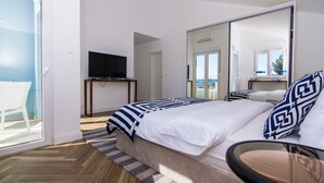 Une chambre d’hôtel équipée d’un lit, d’une télévision, d’un bureau et d’un balcon.