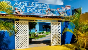 The entrance to Aquarios do Porto with a blue and yellow facade, featuring a large aquarium sign and a website URL. - Pousada Aquários do Porto (Ipojuca)