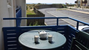 A balcony with a table set for two, a teapot, and two cups. - Apartment by the sea, Bleu Marine Lacanau Ocean residence France (Lacanau Océan)