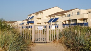 A residential building with a gated entrance, solar panels on the roof, and a sign indicating private property. - Apartment by the sea, Bleu Marine Lacanau Ocean residence France (Lacanau Océan)