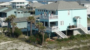 A coastal building with a balcony, a staircase leading to the upper floor, and a view of the beach. - GULF FRONT PENSACOLA BEACH 4BD/3BA HEATED POOL PET FRIENDLY (Gulf Breeze)
