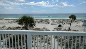 A beach view from a balcony with a railing, sandy beach, sparse vegetation, and the ocean in the background. - GULF FRONT PENSACOLA BEACH 4BD/3BA HEATED POOL PET FRIENDLY (Gulf Breeze)