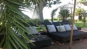 A patio area with wicker furniture and patterned cushions. - Plumbago Guest House (Mbombela)