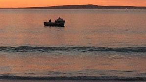 A boat on calm water during sunset. - Sandra's Guest House (Langebaan)