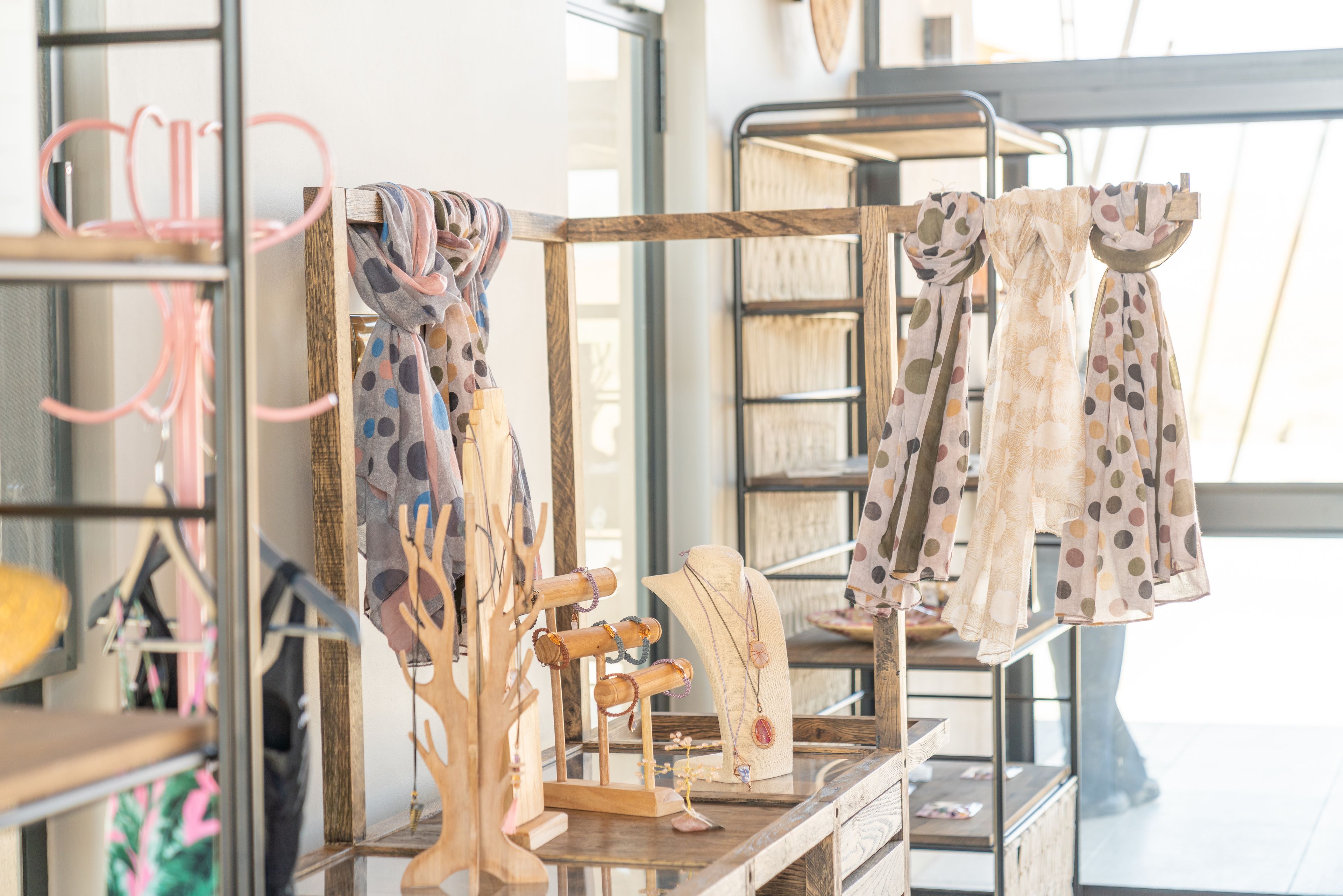 A jewelry display with various necklaces and bracelets on wooden stands.