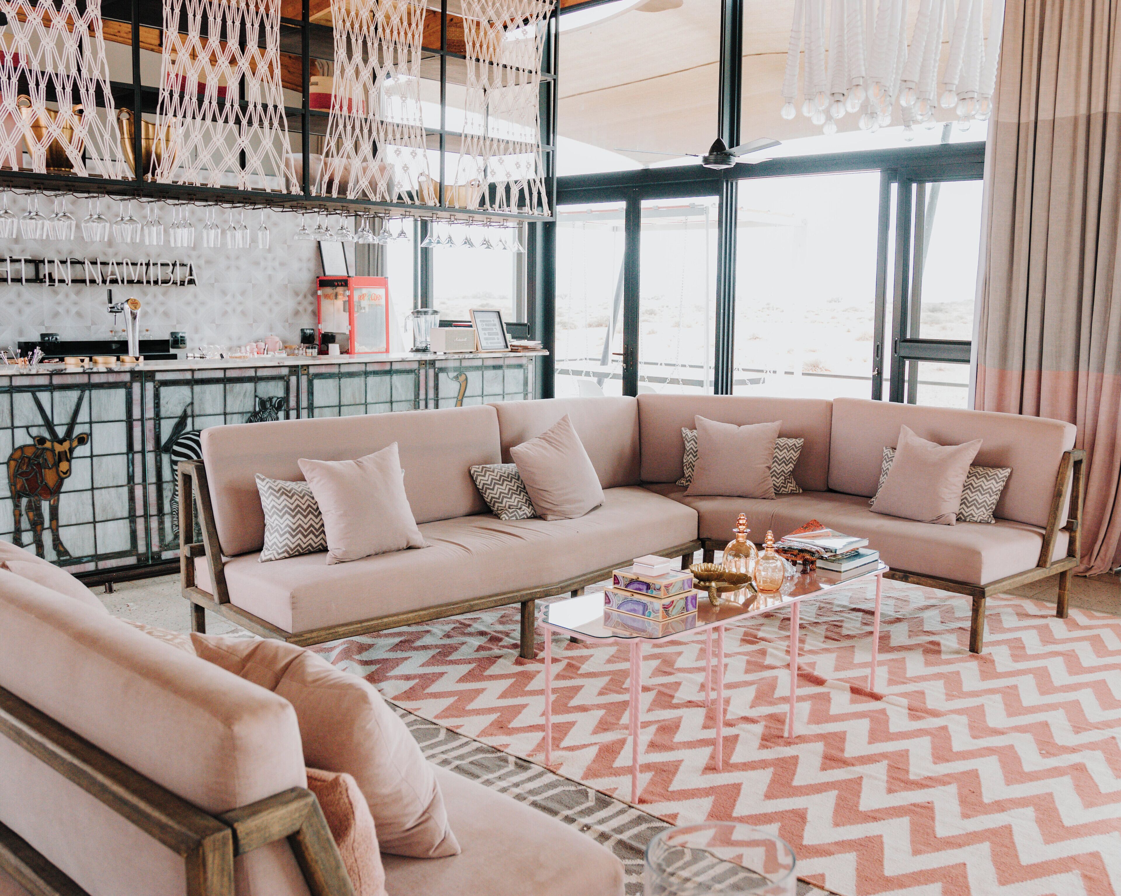 Un salon spacieux avec un grand canapé beige, une table basse et un tapis à motifs.