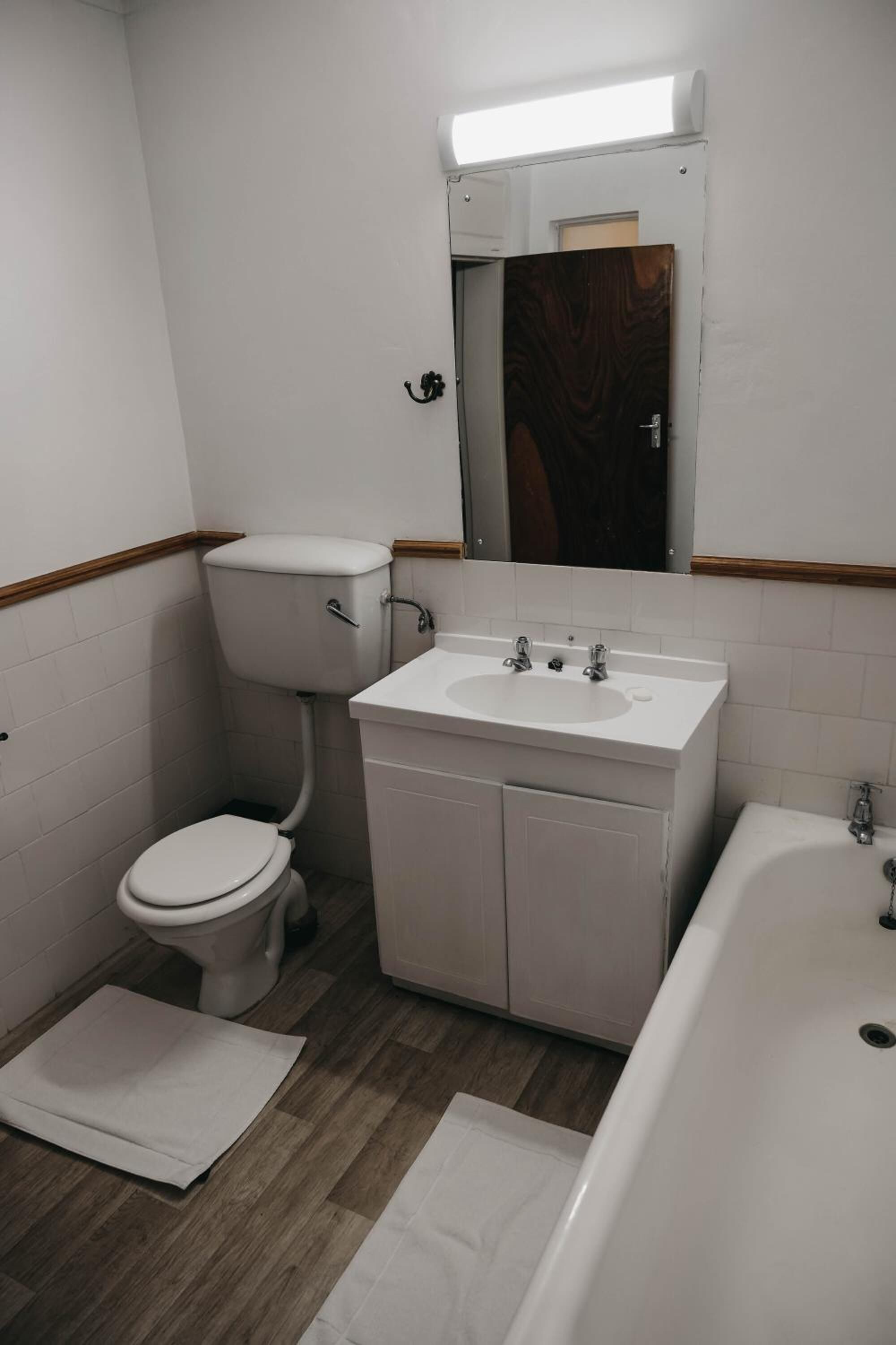 Ein kleines Badezimmer mit Toilette, Waschbecken und Badewanne.