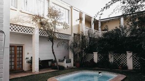 Ein Wohngrundstück mit Swimmingpool, Holztür und weißem Zaun.
