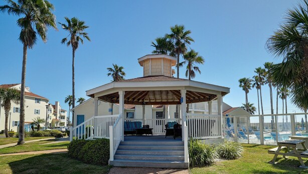 A covered pavilion with a wooden roof, a white railing, and a set of stairs leading up to it. - 1st FLOOR LARGE 1BR, BEAUTIFUL Beach Getaway!  Pool, Hot Tub, Sauna & More (Corpus Christi)