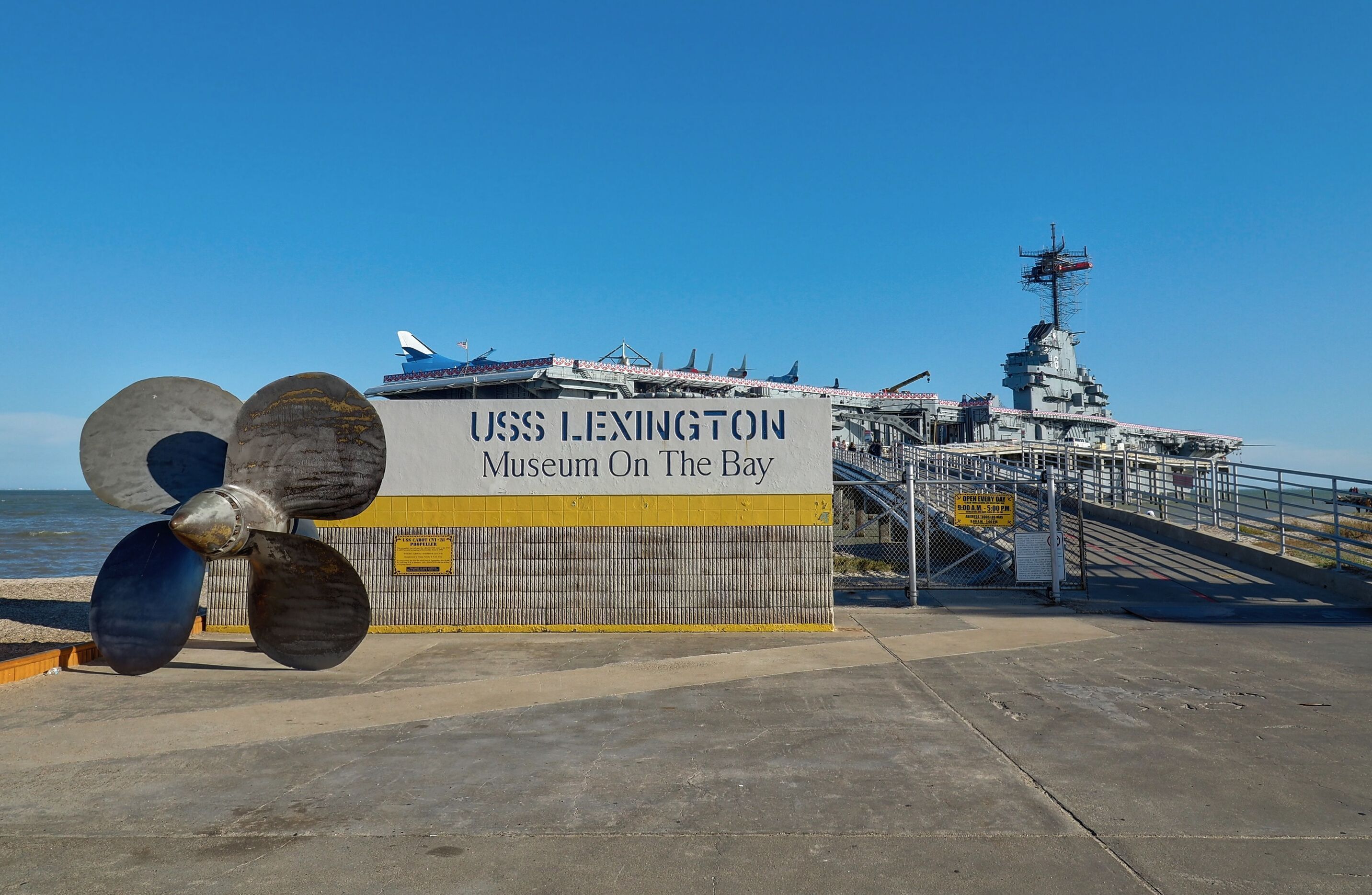 Un gran barco con hélices y un cartel que indica el Museo USS Lexington en la Bahía.