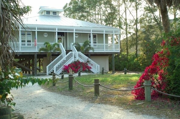 A two-story building with a porch and a staircase leading to the entrance.
