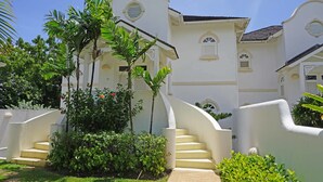 A white building with a curved staircase and lush greenery. - Sugar Hill - B8 by Island Villas (Holetown)