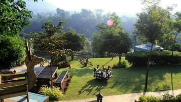 A well-maintained garden with a wooden bench, a small table, and a swing set.