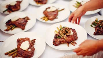 Una mesa con varios platos de carne, cada uno con un trozo de mantequilla y adornado con verduras.