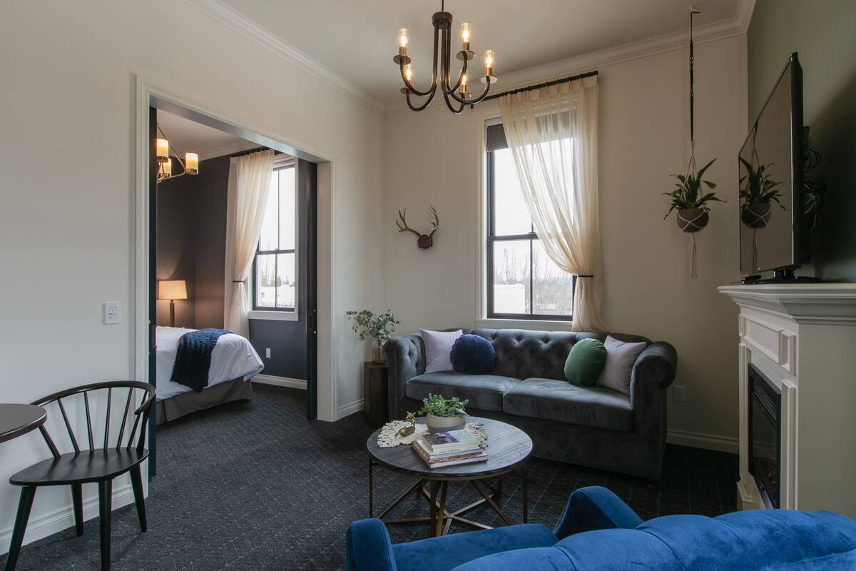 A cozy living room with a sofa, a coffee table, and a fireplace.