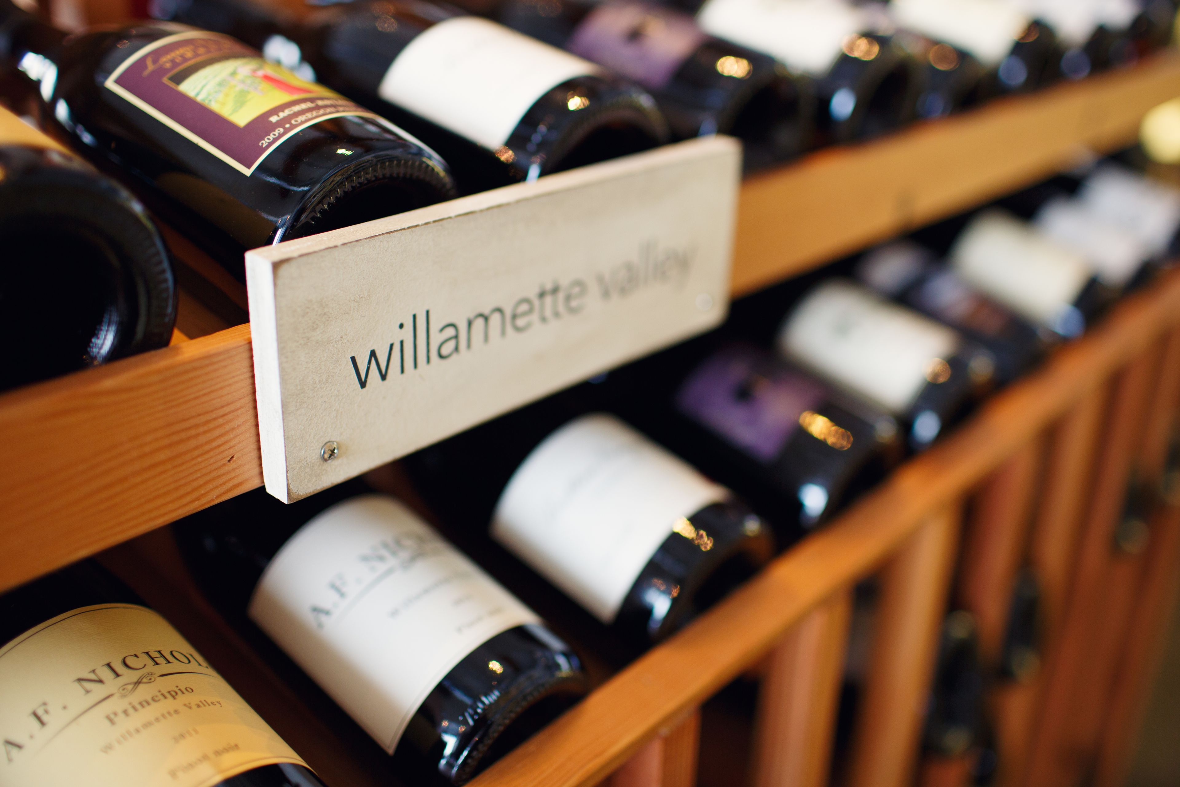A wine rack with labels indicating different wine varieties.