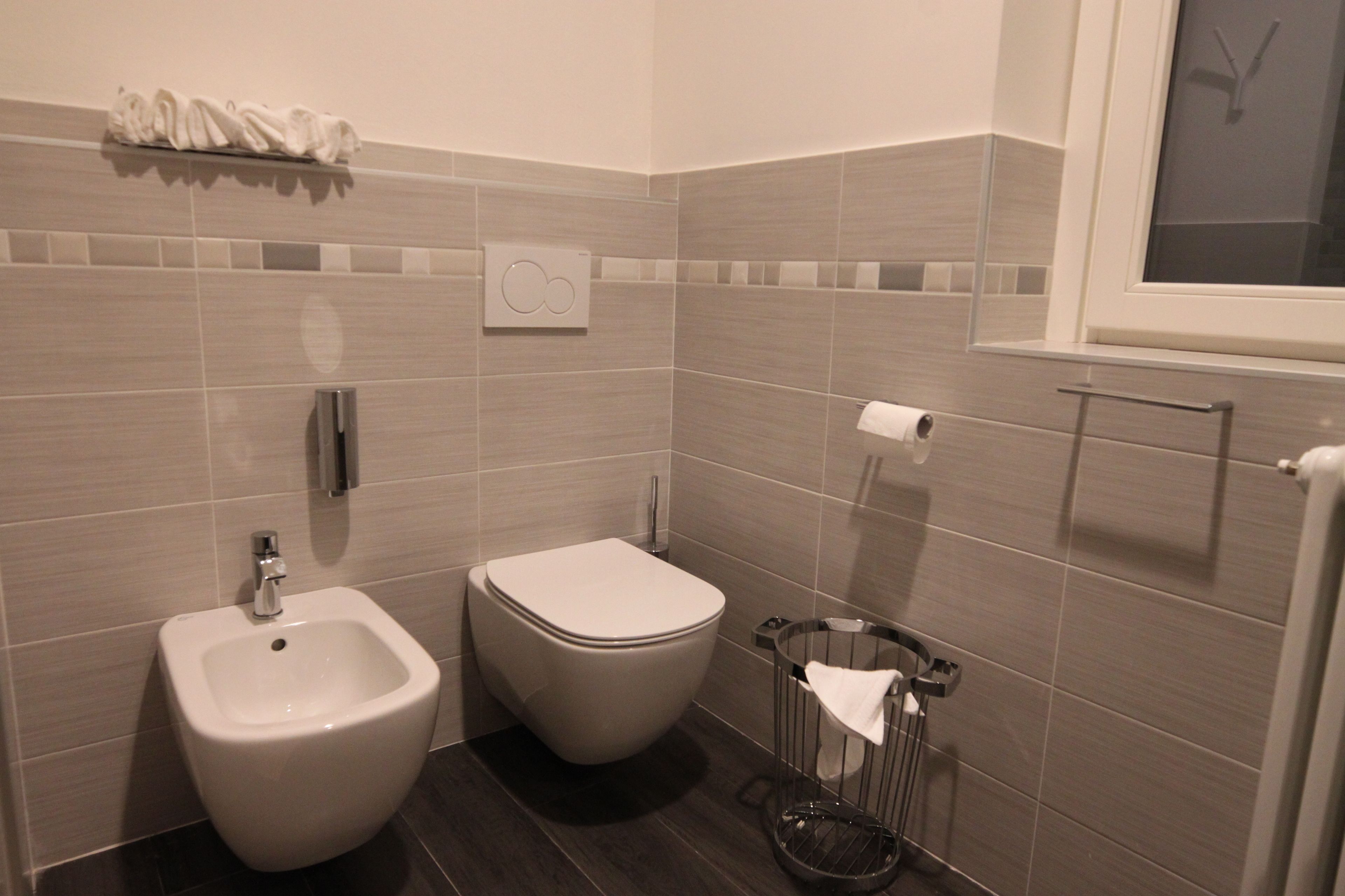 Ein modernes Badezimmer mit integriertem Bidet, Toilette und Handtuchhalter.
