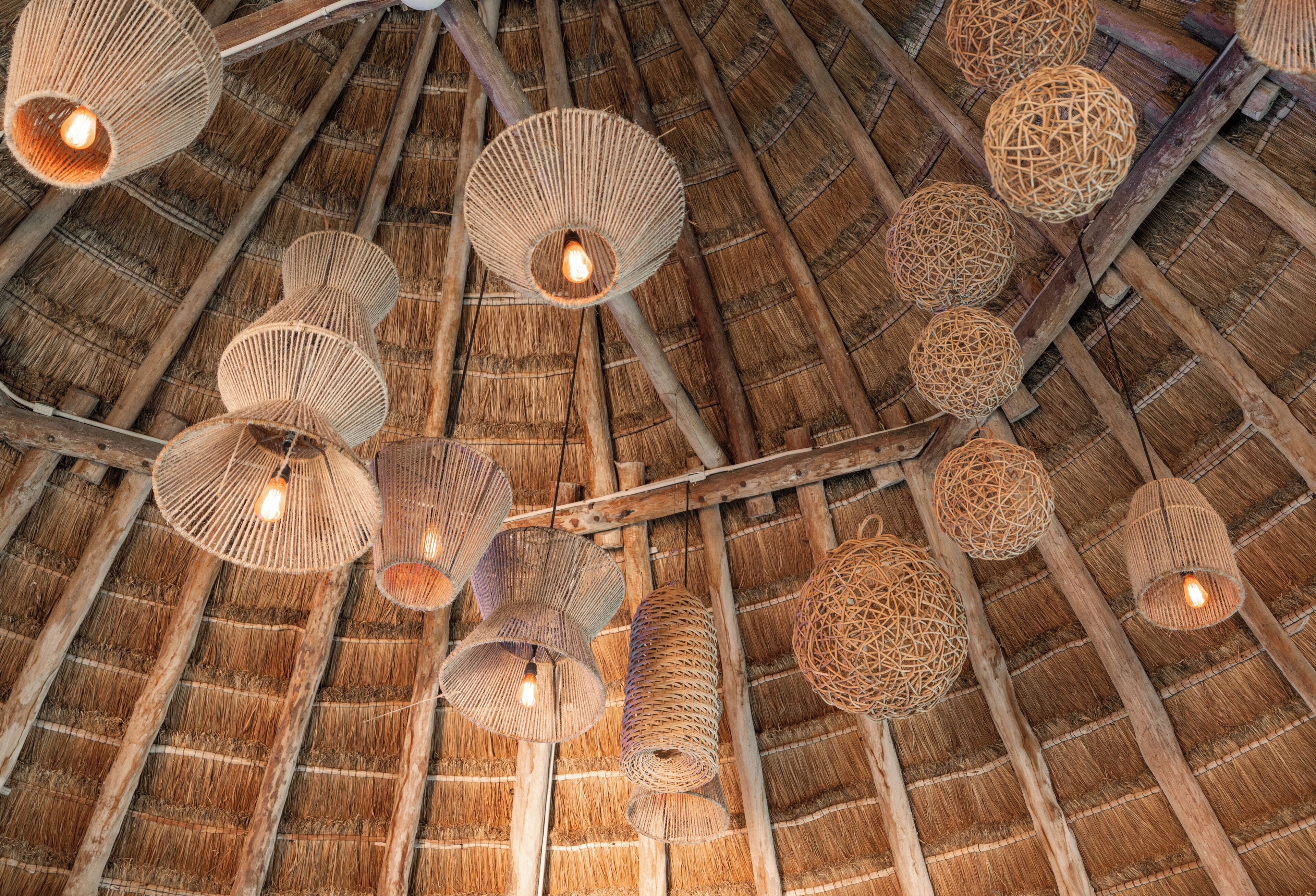 A thatched roof with multiple woven light fixtures.