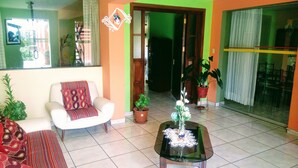 A living room with a sofa, a coffee table, and potted plants. - Casa Baraquel (Arequipa)