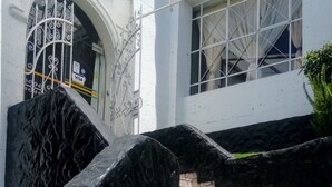 A staircase leading to a building entrance with a metal gate and a Visa sign. - Casa Baraquel (Arequipa)