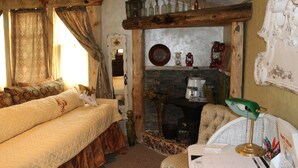 A rustic room with a bed, a fireplace, and a desk with a lamp. - Amie St.Jéan Bed and Breakfast (Rapid City)