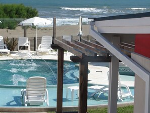 Una piscina techada, una piscina al aire libre de temporada, sombrillas