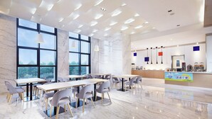 A modern dining area with marble walls, large windows, and contemporary furniture. - Holiday Inn Express Qingdao West Coast by IHG (Qingdao)