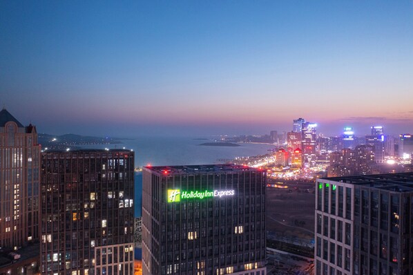 Une vue sur une ville au crépuscule, avec un hôtel Holiday Inn Express bien visible.