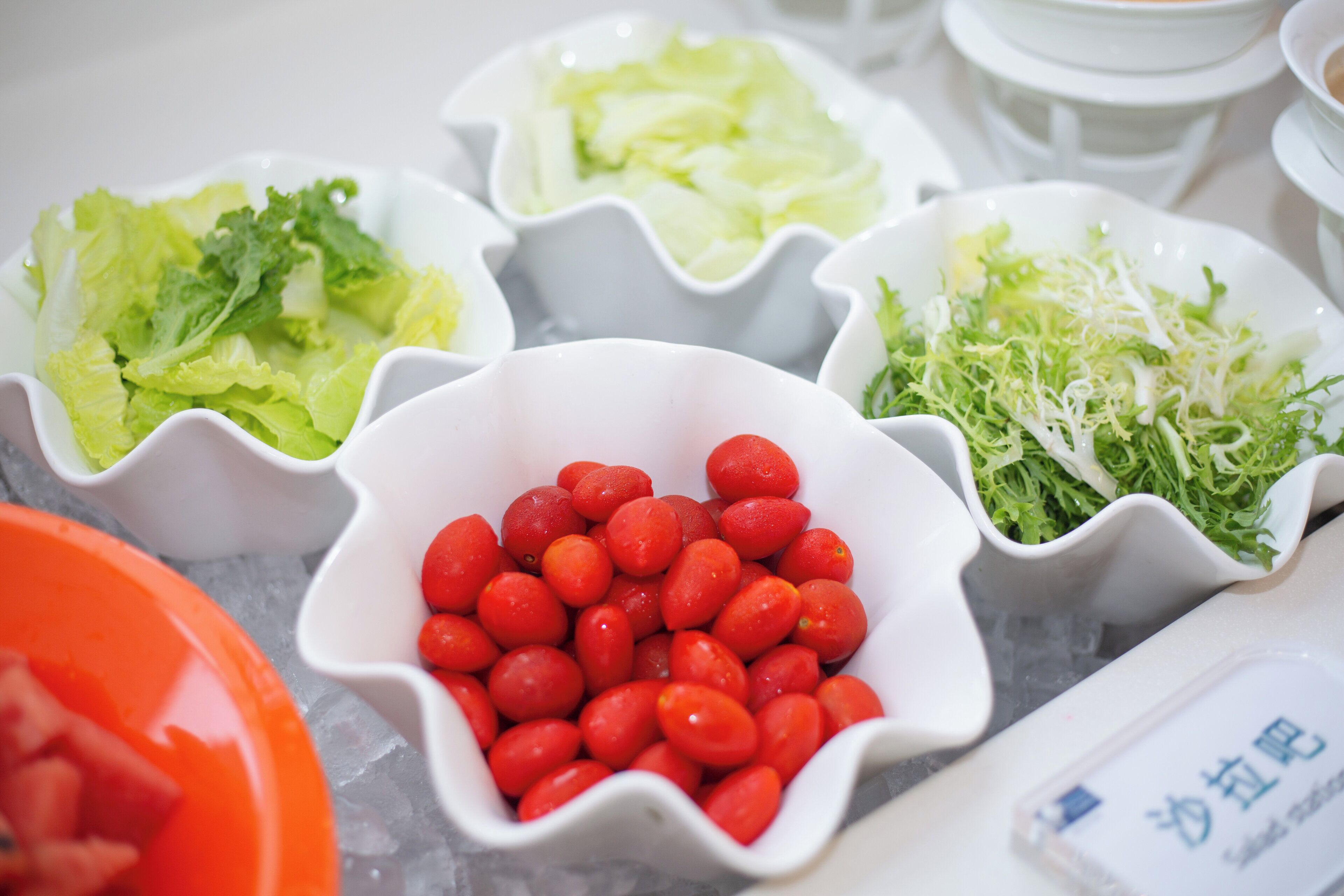 A variety of food items in white bowls on a table.