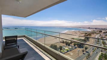 Ein Balkon mit freiem Blick auf Strand und Meer.