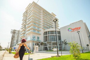 Un moderno edificio de hotel con fachada curva y un logotipo destacado.