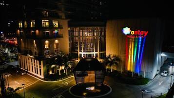 Un hotel con un cartel llamativo, un patio central y una fachada de edificio moderna.