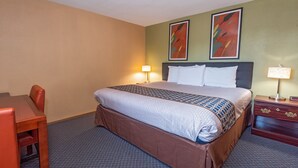 A hotel room with a bed, a desk, and two chairs. - Far West Motel (Forks)