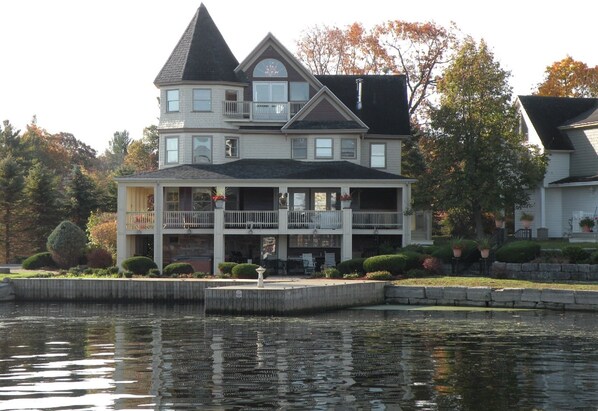 Situated by the water, this charming home offers a wrap-around porch and a bay window on the second floor.
